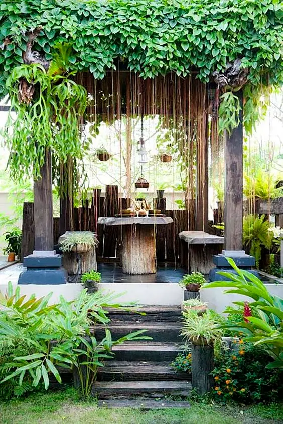 rustic stand alone pergola with tropical climbers