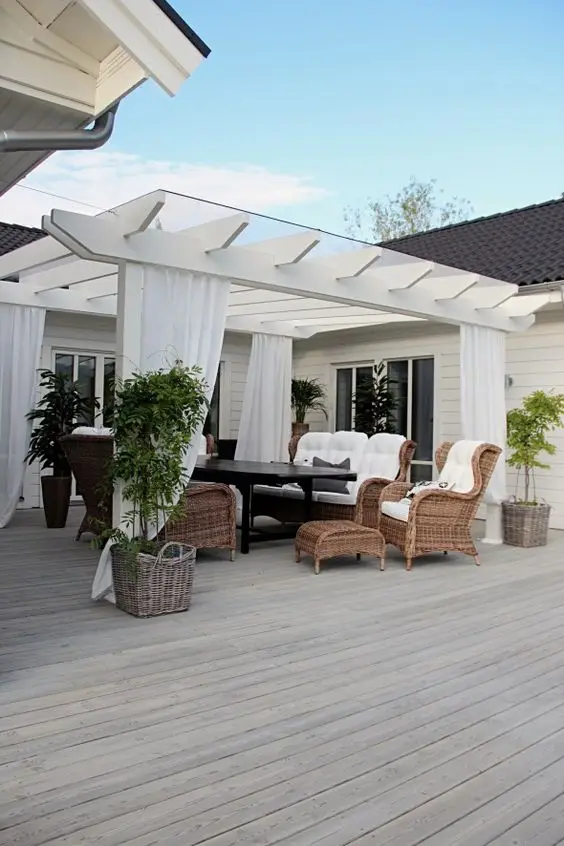 charming white deck pergola with wicker furniture