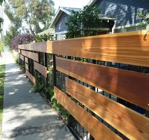 Horizontal Stained Boards fence: Stained boards fixed horizontally across an existing iron fence
