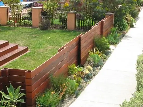 Modern Wood Textured Fence: A knee-high fence in textured timber, there to frame the lawn rather than defend it