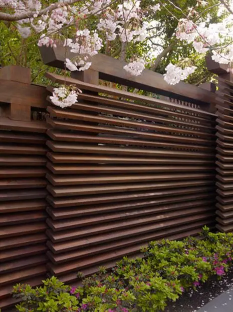 Louvre Privacy Wall fence: Dark, heavy timbers with the slats angled like louvres, a style with a Japanese accent