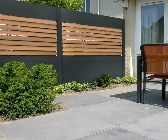 Modern Wood and Concrete Wall fence: A black concrete wall with a channel cut through its middle, infilled with vertical timber slats