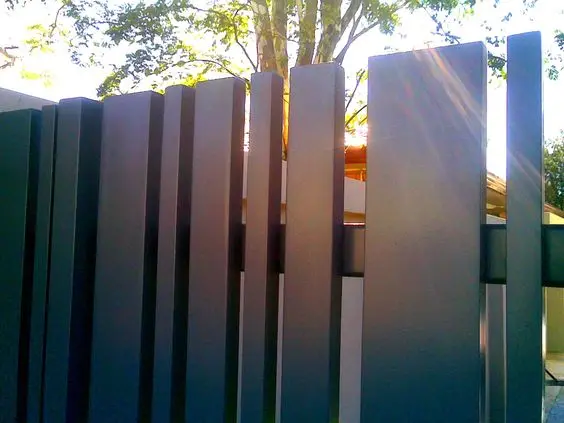 Vertical Slat Fence: Black vertical slats with consistent narrow gaps