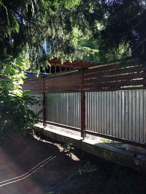 Metal Sheets and Wood Combo fence: Corrugated sheeting framed in timber is about the cheapest real fence you can build