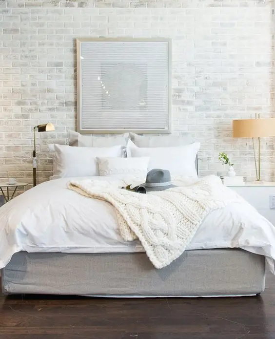 white bedroom with brick wall
