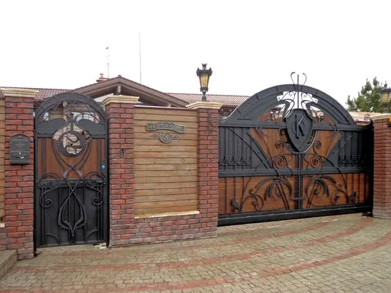 Regal Black Iron front gate: Ornate black ironwork backed with timber panels for privacy