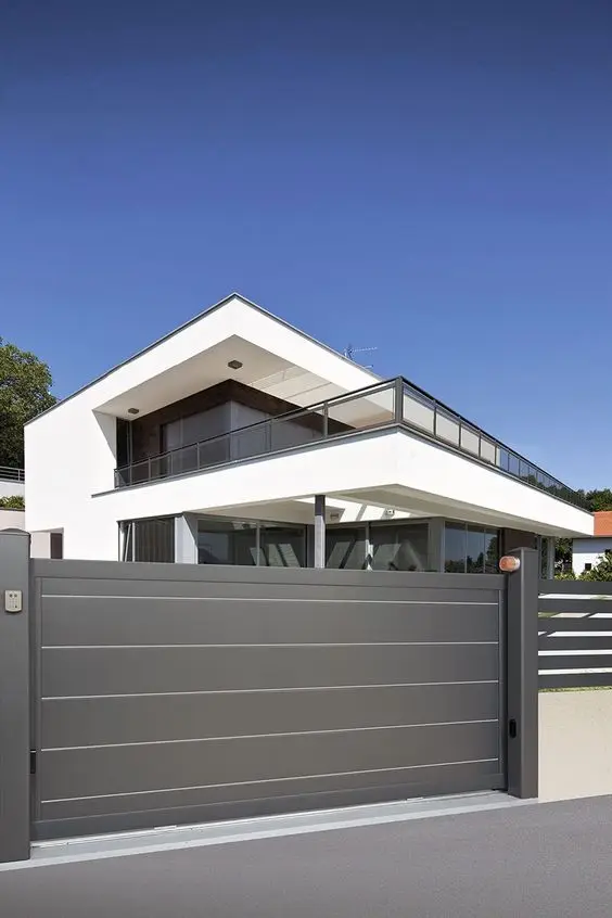 Stunning Grey front gate: A grey driveway gate with thin white lines that pick up the structural lines of the house behind it