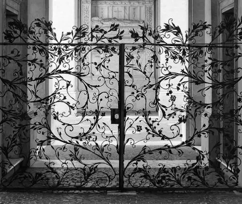 Laced Iron front gate: Filigree iron against cobblestones and old stone columns