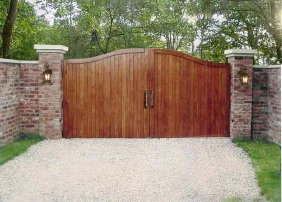 Rustic Ranch Gates: Burnished timber panels under a curved top rail, with iron handles