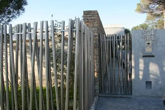 Vertical Pipes front gate: Chrome pipes standing in a row, more sculpture than fence