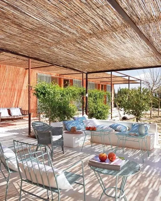 Reed Shade deck and patio: Steel pergola frames roofed with reed panels. The reeds cost little to replace once they weather