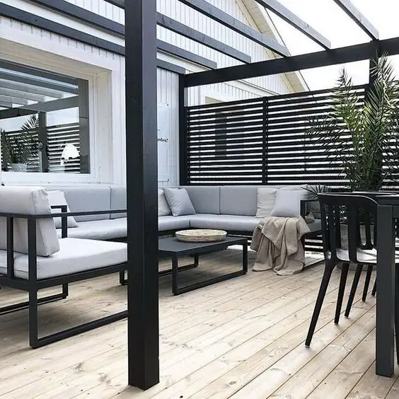 Modern Colours deck and patio: Grey sectional, black pergola and screens, white walls, timber floor. A neutral palette dates