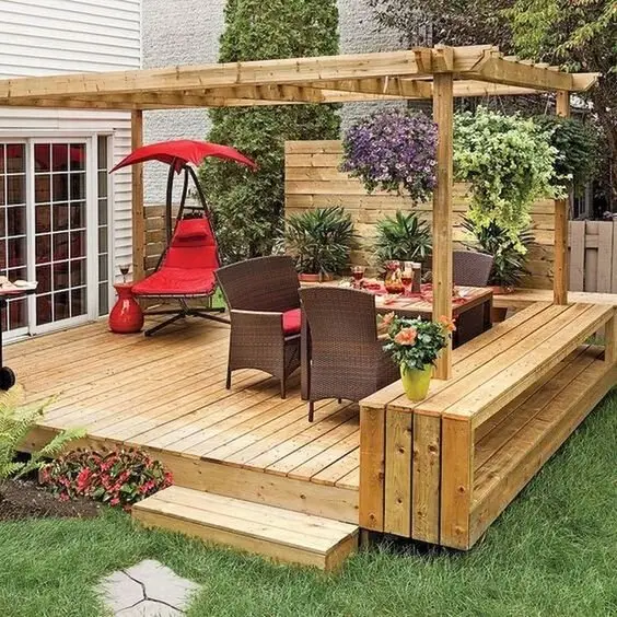 Rustic Outdoors deck and patio: Varnished timber everywhere: decking, pergola, built-in seats. Then one red chair and