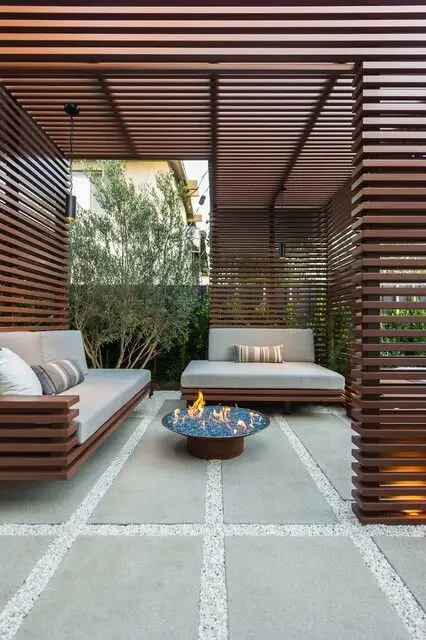 Screened Patio: A big slatted pergola with matching screens, pavers set in pebbles, a fire pit and proper lighting. The