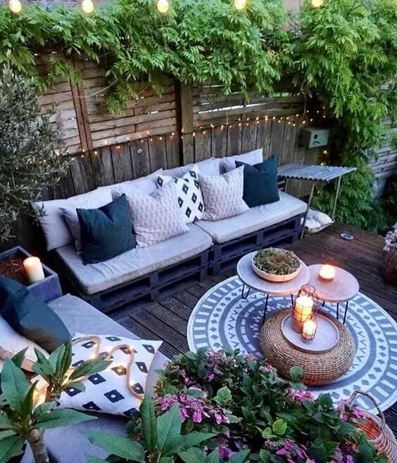 Boho Chic deck and patio: Pallets, seat cushions, string lights, potted plants and a free weekend. That's the whole build