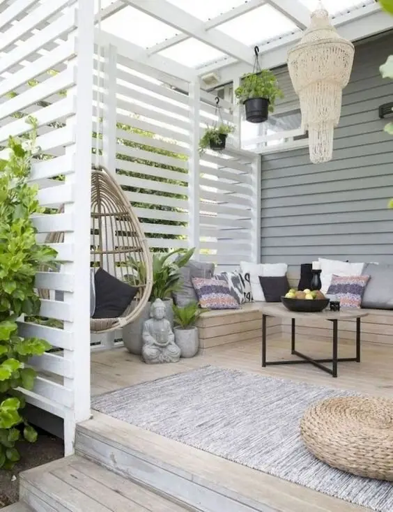 Cosy Cottage deck and patio: A screened deck in all white, with a rattan hanging chair and floor cushions doing the
