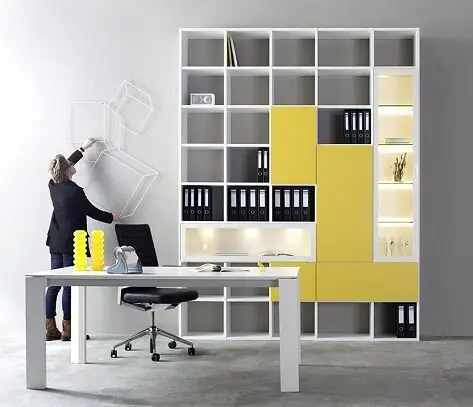 Pops of Yellow minimalist home office: This modern home office consists of a desk, a chair and wall shelving. The modern and