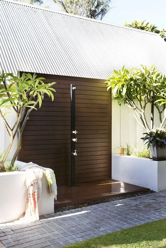 Chocolate on White outdoor shower: Deep brown walls and floor with a minimalist pole. Brown hides water marks and soil