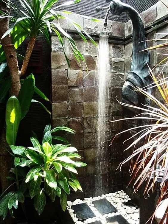 Snaily and Refreshing outdoor shower: A shower enclosure that spirals like a snail shell, in stone and pebbles. The spiral
