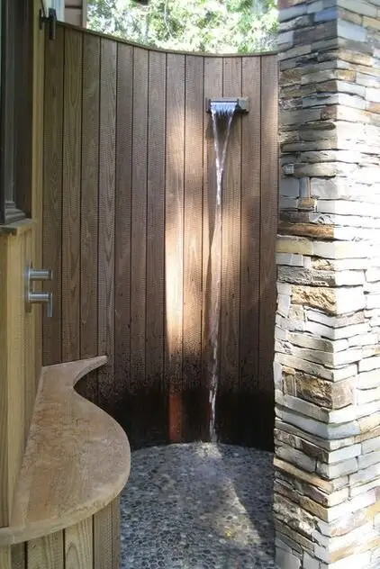 Waterfall Shower: Stacked stone outside, timber lining inside, a waterfall head and a seat. The seat sounds indulgent until