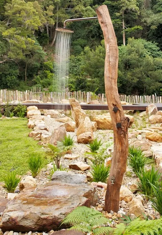 Natural Elements outdoor shower: A tree trunk as the shower pole, a rock slab to stand on, and the garden as the room
