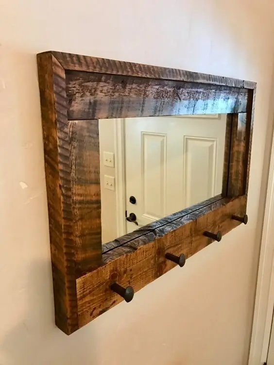 Barnwood Entryway Mirror wood project: Rough boards framed around a mirror, with hooks below for keys and leads. A light
