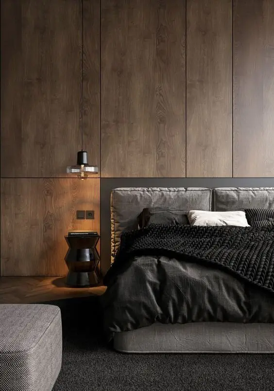 Wood Panels bedroom: Full-height timber panelling in deep tones, a grey and black bed, a vintage pendant