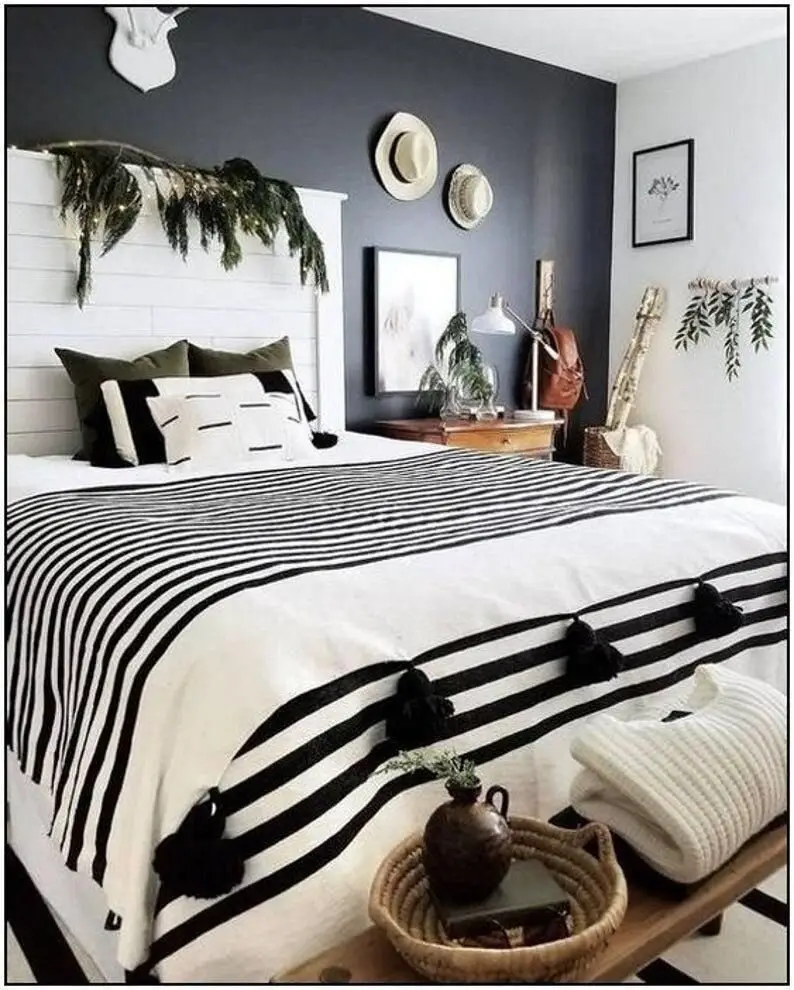 Dashing Bohemian bedroom: A shiplap headboard, one dark grey feature wall, green accents and rustic pieces that look