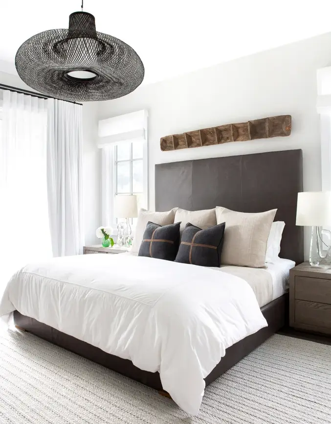 Bright Cottage bedroom: All white, balanced by a woven bamboo pendant, dark timber side tables and a brown headboard