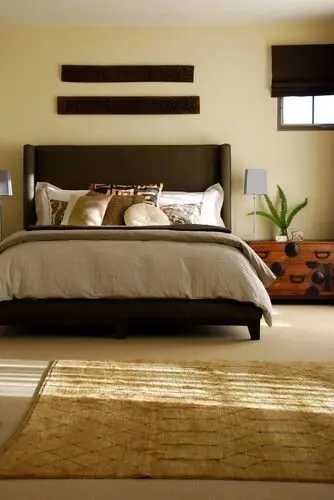 Coffee and Cream bedroom: Warm browns and creams, a high-backed headboard, a seagrass rug and a timber-and-iron side table