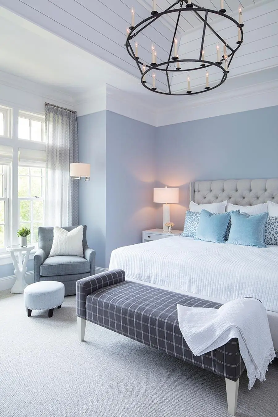 Preppy Pastel bedroom: Cornflower blue walls, white trim, a navy bench and a black chandelier