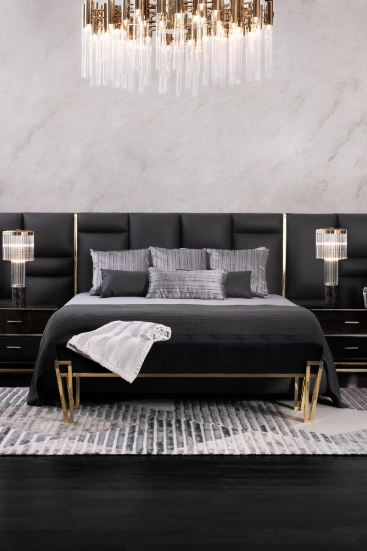 Minimalist Grandeur bedroom: Marble walls, black timber floors, a crystal chandelier and a black leather bed with gold trim