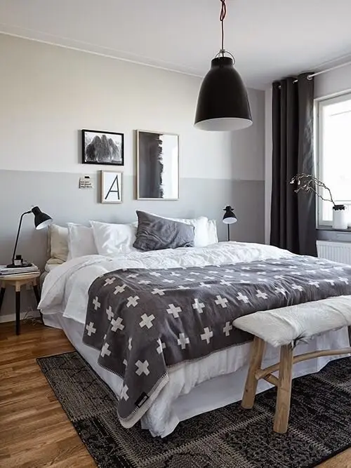 Shades of Grey bedroom: White and grey bedding, a rustic bench, framed prints, matching modern lamps