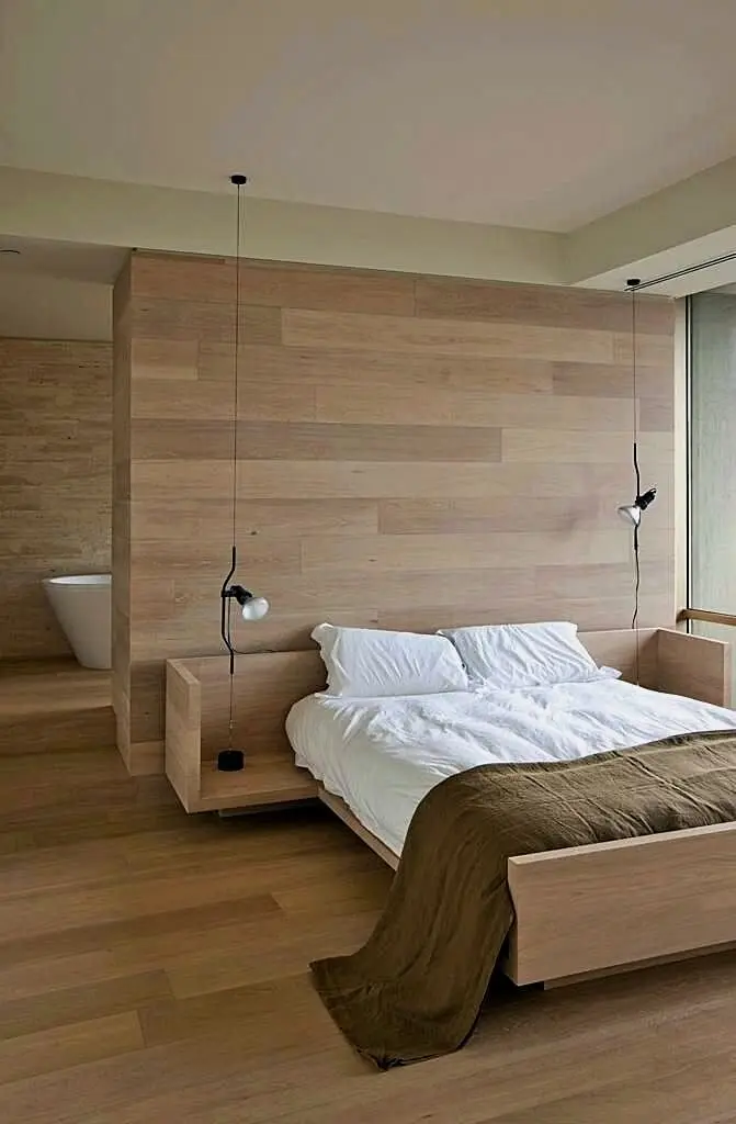 Austere Sophistication bedroom: Light timber across the floor, walls and bed frame, pendants hovering over built-in side tables