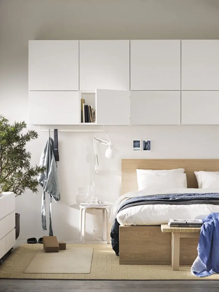 Overhead Storage bedroom: Cabinets running above the bed take everything from clothes to chargers off the floor