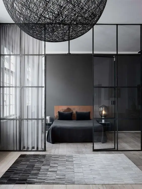Grey Minimalist bedroom: Greys layered on greys: a matte feature wall, an ombre rug, wispy curtains