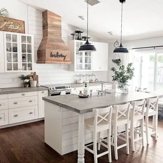 Hamptons Elegance farmhouse kitchen: Shiplap, a timber-panelled rangehood, vintage jars and X-frame chairs, all in white