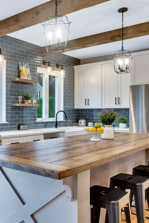 Butcher Block farmhouse kitchen: A butcher's block island under exposed beams and vintage pendants. Work the timber hard. A