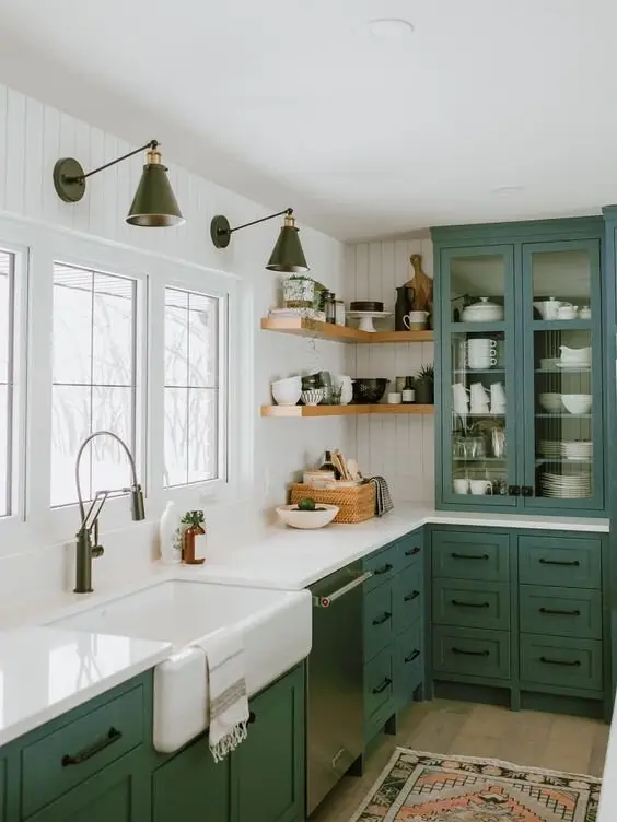Modern Green farmhouse kitchen: Sage green cabinetry with vertical shiplap, an apron sink and green sconces. Green is having