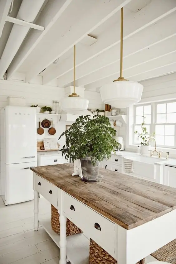 Rustic White farmhouse kitchen: All white, interrupted only by timber counters, woven baskets and copper pots. This is
