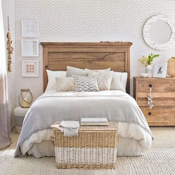 Rustic Haven coastal bedroom: A raw timber headboard and dresser, a wicker basket and a vintage glass lamp over light