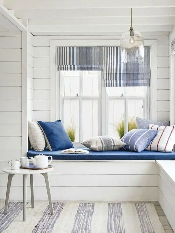 Charming Shiplap coastal bedroom: A window-seat nook in white shiplap with stripes of coastal colour. Shiplap's real talent