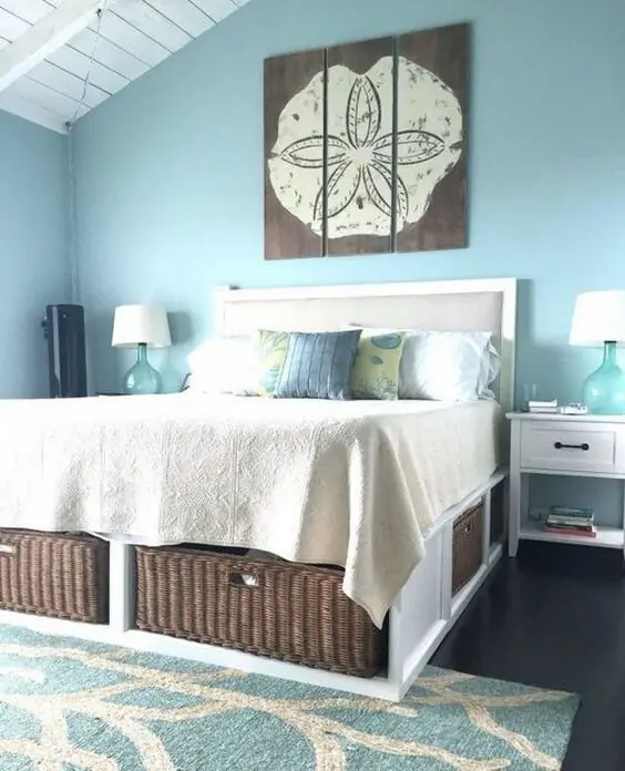 Blue Cottage coastal bedroom: Baby blue walls, a white shiplap ceiling and an elevated bed with storage underneath, plus a