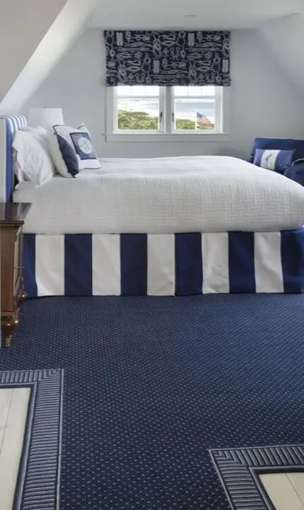 Nautical Blues coastal bedroom: A loft converted with white walls, deep blue carpet and glass. Lofts trap heat, so in an