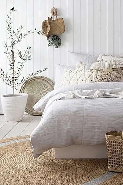 Moroccan Seas coastal bedroom: Moroccan-patterned pillows and a vintage plate on the wall, folded into a bright coastal