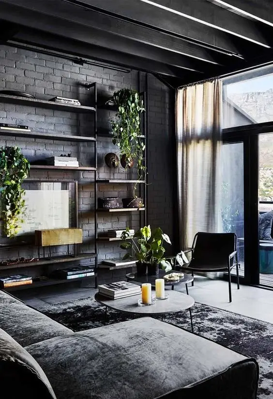 Modern Black industrial living room: This cosy and modern living room features a brick wall painted matte black