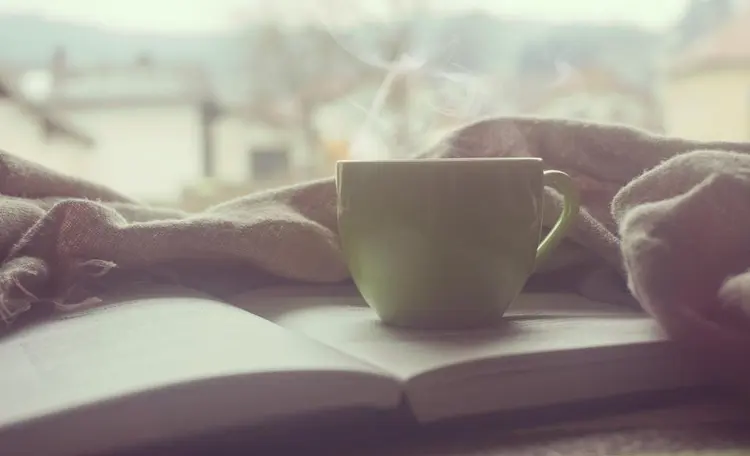 A cup of tea resting on a folded blanket